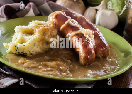 Würstchen mit Kartoffelbrei. Gebackene Wurst im Onion gravy mit Kartoffelpüree serviert. Stockfoto