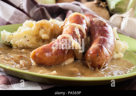 Würstchen mit Kartoffelbrei. Gebackene Wurst im Onion gravy mit Kartoffelpüree serviert. Stockfoto