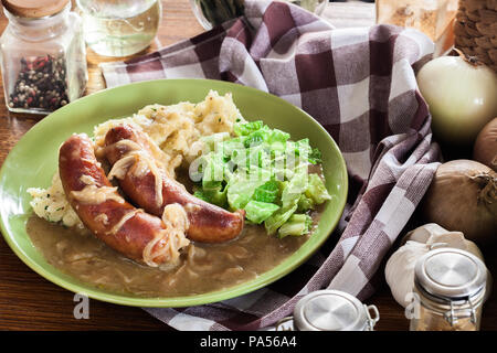 Würstchen mit Kartoffelbrei. Gebackene Wurst im Onion gravy mit Kartoffelpüree und Rotkohl serviert. Stockfoto