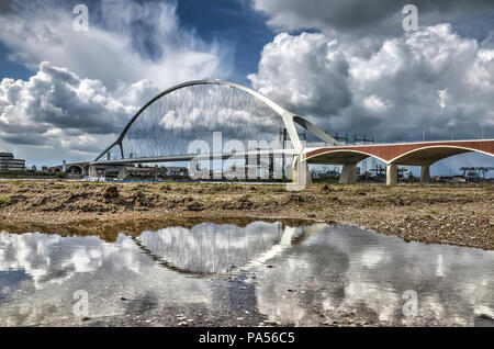 Reflexion der neuen Stadt Brücke De Oversteek (Kreuzung) in einer Pfütze in der Aue des Flusses Waal in der Nähe von Nijmegen, Niederlande Stockfoto