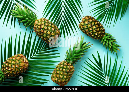 Ananas und tropischen Palmen Blätter auf Pastell türkis Hintergrund. Sommer Konzept. Kreative Flachbild alay mit kopieren. Ansicht von oben. Stockfoto