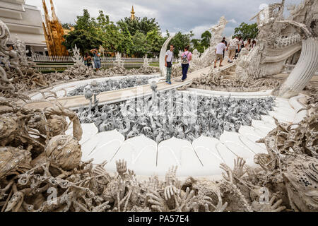 Chiang Rai (Thailand) - 10 Juni 2017: die Menschen besuchen die Wat Rong Khun, besser bekannt als der weiße Tempel, eine moderne und unkonventionelle Buddh Stockfoto