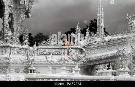 Chiang Rai (Thailand) - 10 Juni 2017: ein buddhistischer Mönch ist zu Fuß auf der Wat Rong Khun, besser bekannt als der weiße Tempel, ein Zeitgenosse und unconventi Stockfoto