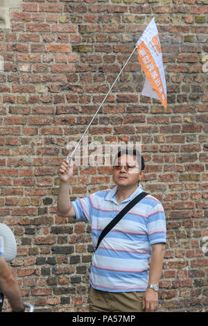 Flagge durch die Tour Führer einer Gruppe chinesischer Touristen, die in der Universität von Cambridge, England (außerhalb von Queens' College). Stockfoto