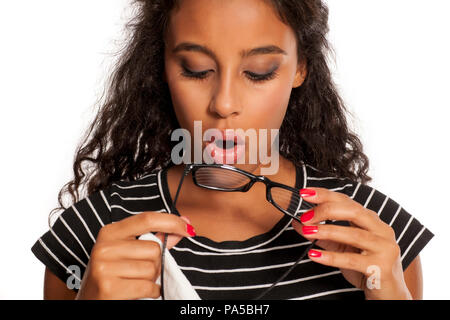 Schöne junge dunkelhäutige Frau, die ihre Brillen Reinigung Stockfoto