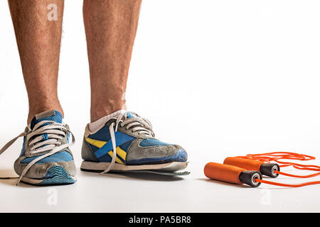 Mann, das Tragen von verschlissenen Paar Trainer, weisser Hintergrund mit kopieren. Stockfoto