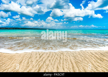 Wave Abwasch über den Sand am tropischen Strand an einem sonnigen Tag Stockfoto