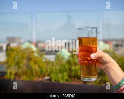 Womans hand Glas IPA Bier auf eine Bar auf der Dachterrasse im Sommer Stockfoto