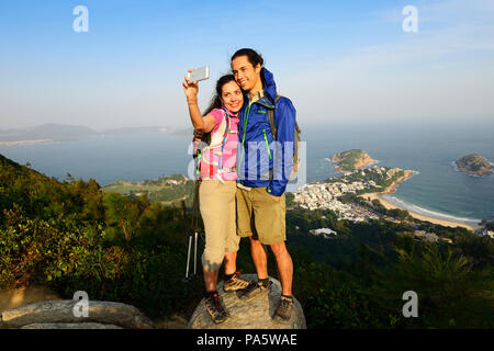 Wanderer eine selfie auf einem Felsen, Drachen zurück Trail, Aussicht auf Shek O Bay, Hong Kong, China Stockfoto