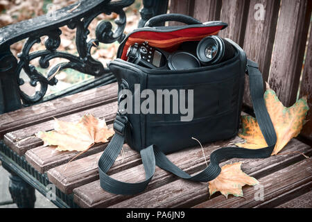 Auf einer Bank mit gelben Blätter im Herbst Park liegt Stockfoto