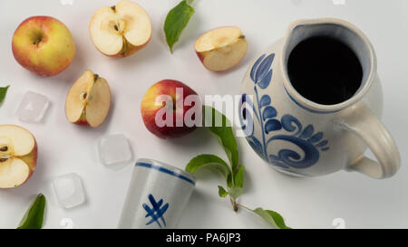 Den traditionellen Apfelwein in einem Krug bembel mit Messbecher und Äpfel auf weißem Hintergrund Stockfoto