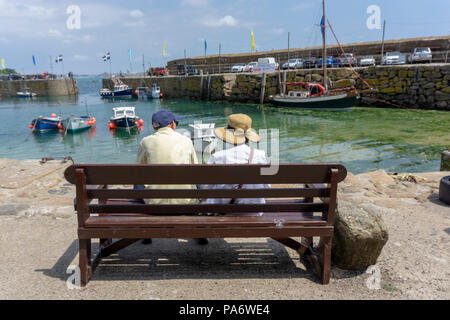Zwei Besucher auf einer Bank in Fowey, Cornwall, Großbritannien Stockfoto