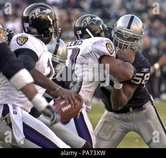 Oakland, Kalifornien, USA. 14. Dez 2003. Baltimore Ravens zurück läuft Jamal Lewis (31) hält den Oakland Raiders linebacker Napoleon Harris (58) am Sonntag, 12 Dezember, 2003 in Oakland, Kalifornien. Die Räuber besiegt die Ravens 20-12. Credit: Al Golub/ZUMA Draht/Alamy leben Nachrichten Stockfoto