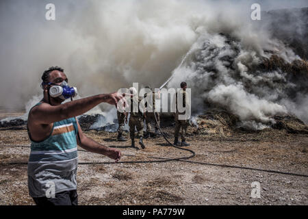 Nahal Oz, im Süden Israels, 21. Juli 2018. Israelische Soldaten ein Feuer, die angeblich durch einen brennenden Ballon gestartet wurde Löschen gesendet aus dem Gazastreifen auf einem Milchviehbetrieb in der Nähe des Israeli-Gaza Grenze in Nahal Oz, im Süden Israels, 21. Juli 2018. Die Hamas einen Waffenstillstand mit Israel im Gazastreifen erklärt hat, sagte ein Sprecher der Hamas Anfang Samstag, nach einem Tag der Gewalt, sah ein israelischer Soldat und vier Palästinenser getötet. Foto: Ilia Yefimovich/dpa Quelle: dpa Picture alliance/Alamy leben Nachrichten Stockfoto