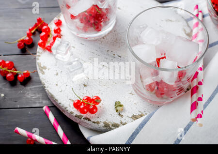 Zwei Gläser mit einem Cocktail aus roten Johannisbeeren und Eis und berryes in Schüssel auf einem dunklen Hintergrund? Platz kopieren Stockfoto