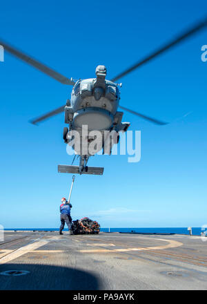 180720-N-ER 318-1120 philippinischen Meer (20 Juli 2018) Segler, die ticonderoga-Klasse geführte-missile Cruiser USS Antietam (CG54) bereiten Sie eine Ladung an einem MH-60R Sea Hawk Hubschrauber, Die "Warlords" von Hubschrauber Maritime Strike Squadron (HSM) 51 zugeordnet, da sie über dem Schiff Flight Deck schwebt. Antietam freut - in den USA 7 Flotte Bereich für Maßnahmen zur Erhöhung der Sicherheit und Stabilität in der indopazifischen Region bereitgestellt. (U.S. Marine Foto von Mass Communication Specialist 2. Klasse William McCann/Freigegeben) Stockfoto