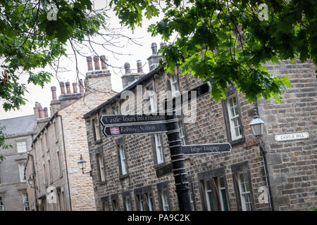 Suchen bis zu einer Straße Wegweiser in der Nähe der Burg in Lancaster City Center mit Bäumen, Stadt, Gebäude, Schornsteine und Sky Stockfoto