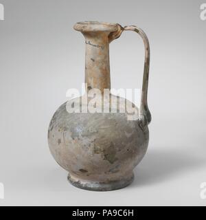 Glaskanne. Kultur: Roman. Abmessungen: 5 1/8 in. (13 cm) Andere: 3 5/16 in. (8,4 cm) Durchm. Von rim: 1 3/8 in. (3,5 cm) Durchm. Der Fuß: 2. (5,1 cm). Datum: Mitte 1.-2. Jh. N.CHR.. Translucent Hellblau grün; in der gleichen Farbe. Rim ausgeklappt, rund, und in der, mit abgeschrägten Kanten; abfackeln Mund; hohe, zylindrische Hals, mit schnittspuren an der Basis; kugelförmigen Körper; integrierter Base Ring mit ausgeprägter nach außen falten; flache Unterseite; flache Unterseite; Strap Griff der drei Rippen, als eine Dicke, Breite Pad zum oberen Körper, ausgearbeitet und gebogen, dann schleppte am äußeren Rand von Rim und oben am Hals. Brok Stockfoto