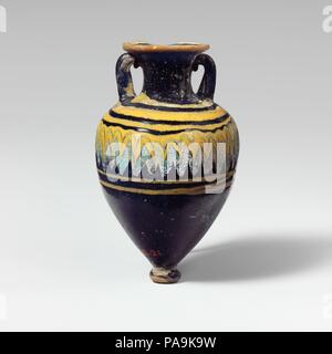 Glas amphoriskos (Parfüm Flasche). Kultur: Griechisch, östlichen Mittelmeer. Abmessungen: H.3 1/8 in. (8 cm). Datum: Ende 6.-5. vorchristlichen Jahrhundert. Transluzent blau, mit Griffen in der gleichen Farbe; Wanderwege in Opak gelb, opak türkis blau. Breit, leicht nach innen geneigten Rim-disk; zylindrische Hals mit konkaven Seiten; breite schräge Schulter; top-geformten Körper; kleine Runde base-Knopf mit flachem Boden; zwei vertikale Schlaufe Griffe angewendet an Schulter, erarbeitet und auf Hals und an der Unterseite der Scheibe gedrückt-rim. Eine gelbe Markierung am Rand des RIM-Festplatte angeschlossen; eine andere dicken gelben Wanderweg an der Basis der angewandten Stockfoto