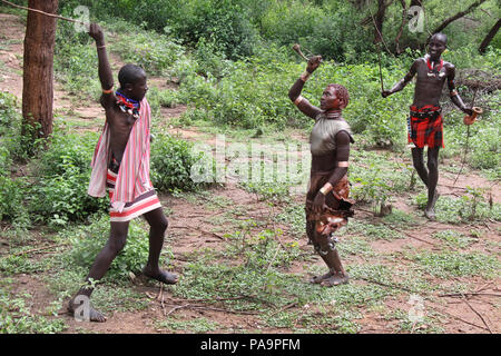 Hamer Mann spannend eine Frau während der Stier springen Zeremonie (Ukuli ritual) von Hamer Hamar Stamm, Äthiopien Stockfoto