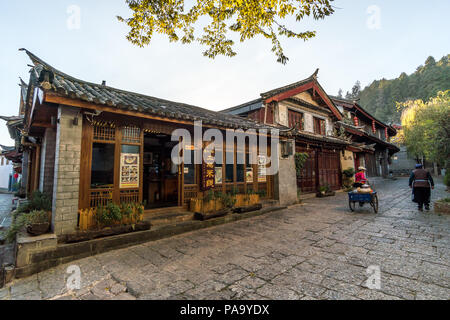 Malerische Straße in der Altstadt von Lijiang, Provinz Yunnan, China. Holz- Fassaden der traditionellen chinesischen Häusern. Die Altstadt von Lijiang ist ein beliebter t Stockfoto