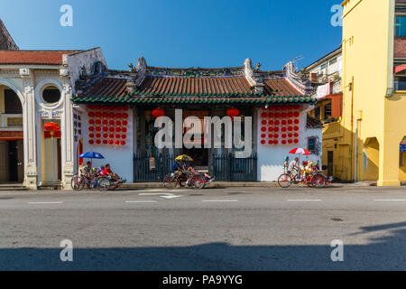 Drei geladene Fahrrad Rikschas ein Clan Haus in Penang verlassen Stockfoto