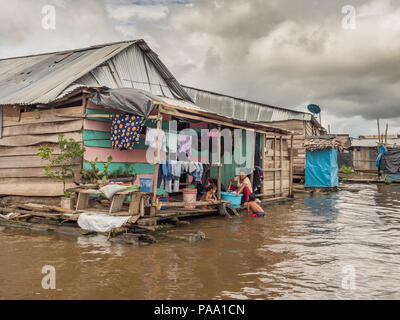 Belen, Peru - 27. März 2018: Familie Wäsche in den Fluss. Schwimmende Häuser in der Flussniederung der Itaya Fluss, ärmsten Teil von Iquitos - Belén Stockfoto