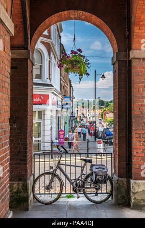 An einem heißen Tag im Juli, Käufer genießen Sie die Vielfalt der Einzelhandelsgeschäfte auf der High Street in Bridport, Dorset. Stockfoto