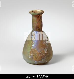 Glas Parfüm Flasche. Kultur: Roman. Abmessungen: 2 15/16 in. (7,4 cm) Durchmesser: 1 3/4 x 7/8 in. (4,4 x 2,2 cm). Datum: 1. Jh. N.CHR.. Farblos mit hellen blau-grüne Färbung. Schiefe rim ausgeklappt, über, und in, und drückte flache, zylindrische Hals, mit schnittspuren um Base; konischen Körper mit konvexen Seiten; flachen Boden. Komplette, aber große Sprung von rimto unten; pinprick blasen; Mattierung, Lochfraß, und brillante irisierende Verwitterung. Museum: Metropolitan Museum of Art, New York, USA. Stockfoto