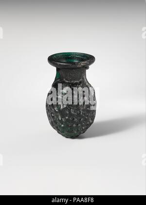 Glas Traubensaft Kolben. Kultur: Roman. Abmessungen: 1 7/8 x 1 3/16 in. (4,8 × 3 cm) Durchm. Von rim: 1 in. (2,6 cm). Datum: 1.-2. Jh. N.CHR.. Transluzente tief smaragdgrün. Rim ausgeklappt, über, und in, und drückte flach in das Abfackeln Mund; kurz, trichterförmigen Hals kugelförmigen Körper mit prominenten Naht vom Hals abwärts Seite und ganz unten; runder Boden. In einem zweiteiligen Negativform relief Dekoration auf Körper bestehend aus fest verpackten kleinen Knöpfe zu produzieren Geblasen, wahrscheinlich die Nachahmung einer Weintraube. Intakt; pinprick blasen; Mattierung, leichte Lochfraß und schwache Schillern. Museum: Mich Stockfoto