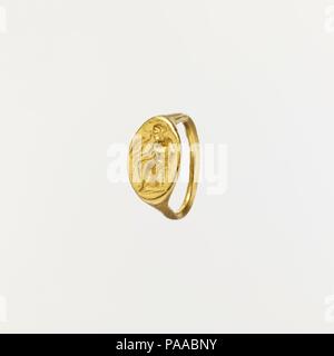 Gold Ring mit Intaglio der sitzende Frau und fliegende Eros. Kultur: Griechisch. Maße: Gesamt: 7 1/16 x 7/16 in. (18 x 1.1cm). Datum: 2.Hälfte des 5.Jh. v. Chr.. Die Blende der Dieser Ring hat eine hervorragend detaillierte Radierung von einer frau angesprochen, die von Eros. Die Frau ist auf einem Hocker sitzend, erwies sich das Bein von der sichtbar ist. Ihr Haar ist ein netzartiges Neglige,Bodies gebunden. Sie trägt Ohrringe, eine Halskette, und auf ihrem rechten Handgelenk, ein Doppelzimmer, ein Armband. Ein belted Chiton deckt ihre Oberarme und ein himation ist um ihre Taille gebündelt, die sich auf die Beine. Falten im Stoff sind parallel Ridges gerendert, o Stockfoto