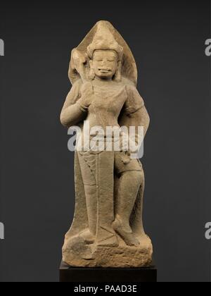 Ständigen Shiva oder Temple Guardian (Dvarapala). Kultur: Vietnam (Champa). Abmessungen: H.50 1/2 in. (128,3 cm). Datum: Ca. die erste Hälfte des 10. Jahrhunderts. An einem wichtigen Seeweg zwischen Indien und China, Champa entfernt, im zentralen Teil von Vietnam, spielte eine wichtige Rolle in der frühen Geschichte Südostasiens. Diese seltene Skulptur, die sich darstellen kann entweder eine Temple Guardian oder des hinduistischen Gottes Shiva, zeigt die robuste sculpting und unverwechselbare Physiognomie, insbesondere den markanten Schnurrbart, dass die Kunst des Chams verkörpern. Er trägt eine kurze Nachbearbeitung, das über eine lange Tasche auf der Vorderseite mit einem schrägen u Stockfoto