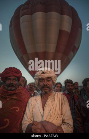 Indische Dorfbewohner in einer Menschenmenge trägt einen Turban, mit einem Heißluftballon hinter seinem Kopf Stockfoto