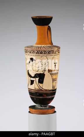 Terrakotta lekythos (Öl Flasche). Kultur: Griechisch, Dachboden. Abmessungen: H.5 3/16 in. (13,1 cm). Datum: 2. Quartal 5. Jahrhundert v. Chr.. Frau sitzt, bevor Kalathos (Wolle Warenkorb) der Maler hier sorgfältig die Wolle hat das Befüllen der Kalathos. Ein Spiegel hängt über. Museum: Metropolitan Museum of Art, New York, USA. Stockfoto