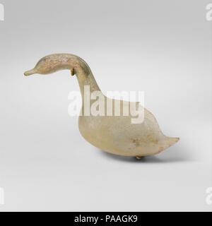Glas Flasche in der Form eines Vogels. Kultur: Roman. Abmessungen: H.: 2 5/8 in. (6,7 cm). Datum: 1. Jh. N.CHR.. Translucent Hellblau grün. Lange, solide, abgerundeten Schnabel; Kopf projizieren nach vorn und leicht nach unten, um röhrenförmige Hals, verschmilzt mit plumpen Körper befestigt. Gebrochen, mit dem hinteren Teil des Körpers und der Schwanz fehlt; wenige Blasen; Mattierung und schwache Irisieren an der Außenseite, cremige irisierende Verwitterung, die innen mit einem Patch von kalkigen Verkrustung. Flaschen dieser Art wurden mit ihren Inhalt (flüssig Parfüm oder Kosmetische Pulver) innen versiegelt. Die Spitze der Rute hatte somit Stockfoto