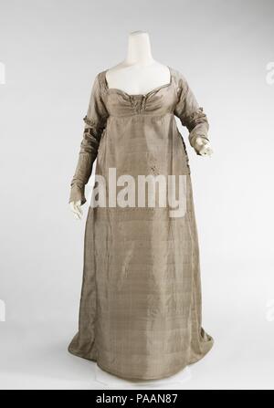 Kleid. Kultur: American. Datum: Ca. 1805. Das Empire Silhouette ist leicht mit seinen Ursprung in der CHITON der alten Greco-Romans, bei der es sich um eine röhrenförmige Kleid von den Schultern drapierten und manchmal unter der Büste belted identifiziert. Mehrere re-Interpretationen haben in Kostüm Geschichte aber keiner aufgetreten sind als bemerkenswert, da der Zeitraum der Überbrückung der rechteckigen panierred Röcke des 18. Jahrhunderts und der Konischen hoop Röcke des 19. Jahrhunderts. Die neoklassizistischen Stil wurde in allen Formen der Dekoration nach der Französischen Revolution verabschiedet und war während der Napoleonischen Kriege bestätigt teilweise du Stockfoto