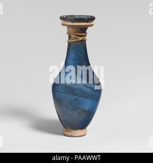 Glaskanne. Kultur: Roman, Rheinische. Abmessungen: H.: 4 1/2 in. (11,4 cm). Datum: 3.-4. Jh. N.CHR.. Transluzente kobalt blau; Trail und Base Ring in semi-blickdichte gelblich weiß. Rim gefaltet und im und in die Seite des abfackeln Mund geglättet; zylindrische Hals, leicht erweitern nach unten; biconical Körper; angewandte Dicke base Ring; Klein, unebenen Boden. Dicke trail Wunde horizontal um die Unterseite der Mund, dann in einem feinen Trail fallengelassen, und die Wunde, drei Mal um die oberen Hals. Body Complete außer kleinen Chip in Rim und Risse um Mund und alle fehlenden behandeln; einige pinpric Stockfoto