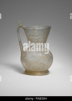 Ewer mit Vögeln und Tieren. Abmessungen: H. 5 3/4 in. (14,5 cm), max. Durchm. 4 in. (10,2 cm), Diam. (Rim) 3 5/8 in. (9,1 cm) Durchm. (Bauch) 4. (10,2 cm) Durchm. (Base) 2 15/16 in. (7,5 cm). Datum: 10. Diese ewer dekoriert mit Vierbeiner und Vögel in roundels, wahrscheinlich in Nishapur hergestellt ist, ist eines der besten Beispiele für Glas Gefäße mit Rad-cut-Designs. Die beiden roundels auf beiden Seiten des Griffs zeigen, Long-tailed Vögel, und der Dritte trägt einen kauernden Löwen. Während dieses war das einzige Schiff in Nishapur mit einem Muster von roundels um seinen Körper gefunden, die Dekoration ist Stockfoto