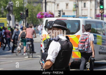 London, England, UK; 13. Juli 2018; zwei weibliche Metropolitan Police Officers in der Straße. Unfocused Polizeiwagen hinter Stockfoto