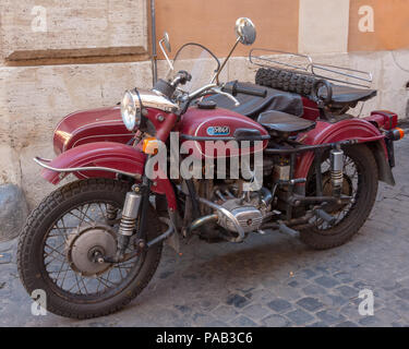 Eine Ural Ypan russischen Motorrad und Auto gut für sein Alter in einem Rom Seitenstraße. Stockfoto
