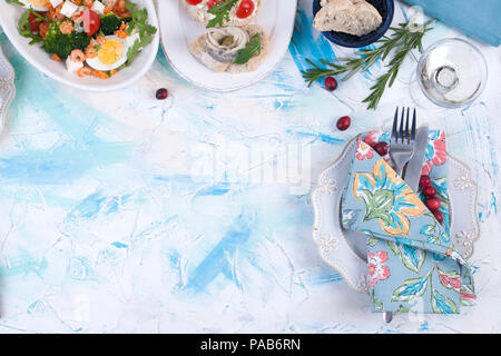 Anderes Essen und einem Glas Wein auf einem weißen Tisch. Stockfoto