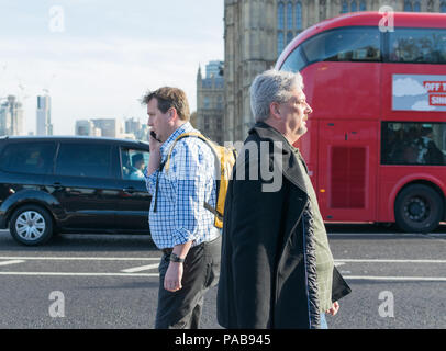 Männer gehen auf die Westminster Bridge, London Stockfoto