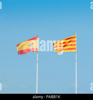 Katalanische und spanische Flaggen fliegen auf einem Mast vor blauem Himmel. Die regionale Regierung Kataloniens Wünsche aus Spanien zu trennen. Stockfoto