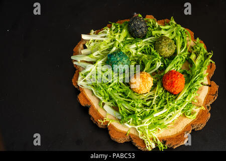 Käse Kugeln auf einem Holzteller mit den Gruenen Stockfoto