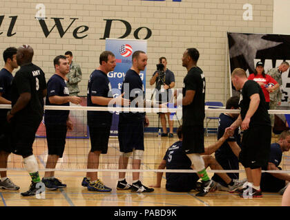 Marine/Küstenwache Teammitglieder shake Hands mit Team Armee nach sitzenden Volleyball spielen während der 2013 Krieger Spiele 14 Mai. Team-Marine verlor gegen Team Armee. Endergebnis war 25 bis 14 im Team Armee gefallen. Die Krieger Spiele umfasst Wettbewerbe im Bogenschießen, Radfahren, sitzende Volleyball, schießen, Schwimmen, Leichtathletik und Rollstuhl-Basketball. Das Ziel der Krieger Spiele ist nicht unbedingt zu die erfahrensten Athleten zu identifizieren, sondern um das unglaubliche Potential der Verwundeten Krieger durch Leistungssport zu demonstrieren. Mehr als 200 Verletzte, kranke oder verletzte Service-Mitglieder aus der Stockfoto