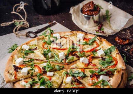 Pizza mit Rucola feta Pfeffer und Laubbäume Tomaten. Italienische Pizza. Stockfoto