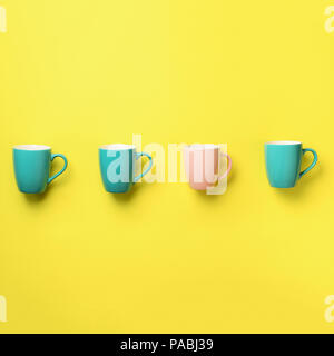 Muster von blau und rosa Tassen auf gelben Hintergrund. Platz crop. Geburtstag Feier, baby Konzept Dusche. Druckvolle Pastellfarben. Minimalistische Stockfoto