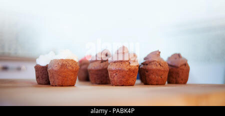 Chocolate Muffins auf den Schreibtisch. Cupcakes mit verschiedenen Cremes. Kopieren Sie Speicherplatz auf der Oberseite Stockfoto