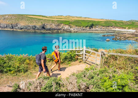 Junges Paar zu Fuß auf den Pembrokeshire Coast Path an Porthlysgi Bay in der Nähe von St Davids, West Wales Stockfoto