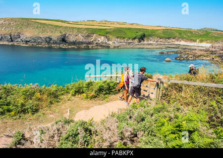 Junges Paar zu Fuß auf den Pembrokeshire Coast Path an Porthlysgi Bay in der Nähe von St Davids, West Wales Stockfoto